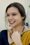 a woman smiling with her hand on her chin