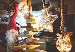 A cozy scene featuring classic red Christmas hats arranged on a rustic wooden table with twinkling fairy lights.