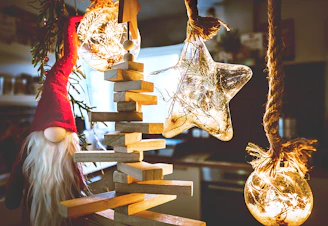 A cozy scene featuring classic red Christmas hats arranged on a rustic wooden table with twinkling fairy lights.