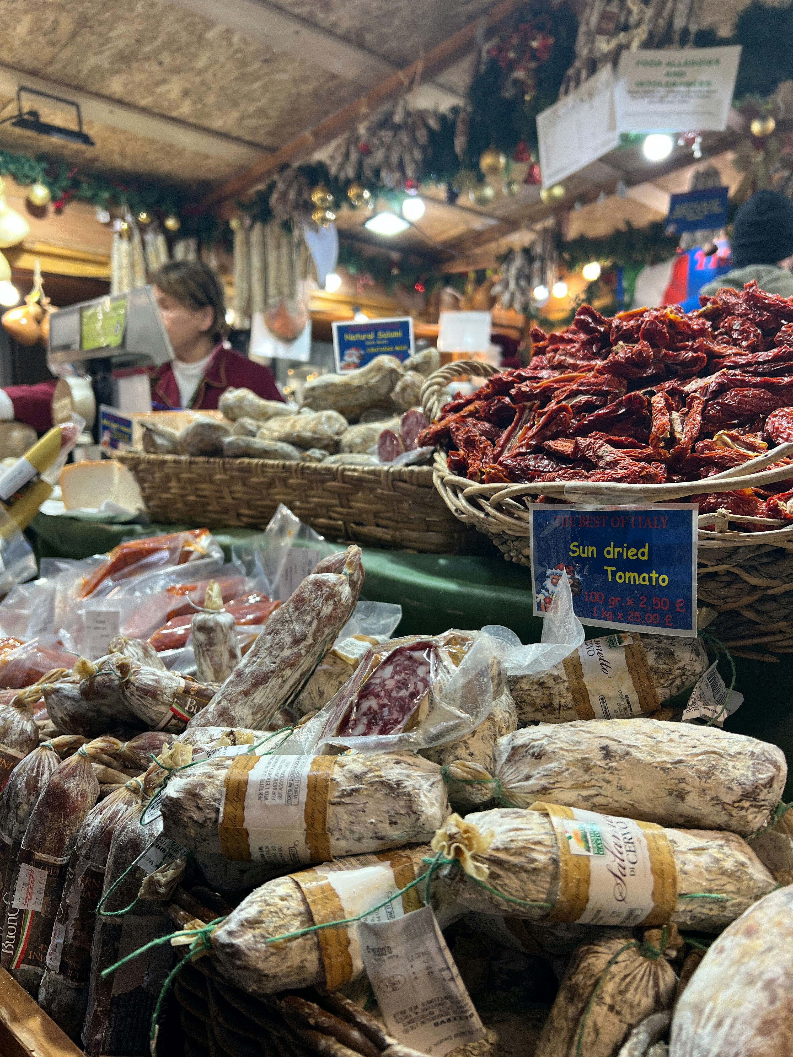 Mercatino di prodotti tipici italiani all'aperto con bancarelle colorate di formaggi, salumi e verdure fresche sotto il sole