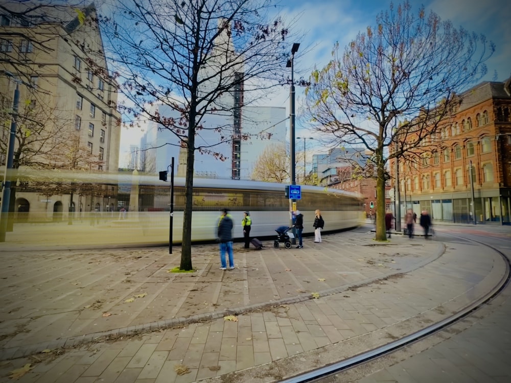 a group of people walking on a sidewalk next to a street