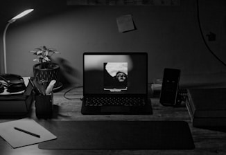 A cozy desk setup with a laptop showing 로투스바카라 game screen and notes about 로투스홀짝 추천.