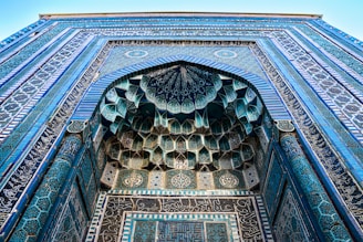 Close-up of a sleek glass storefront facade with Islamic decorative elements.