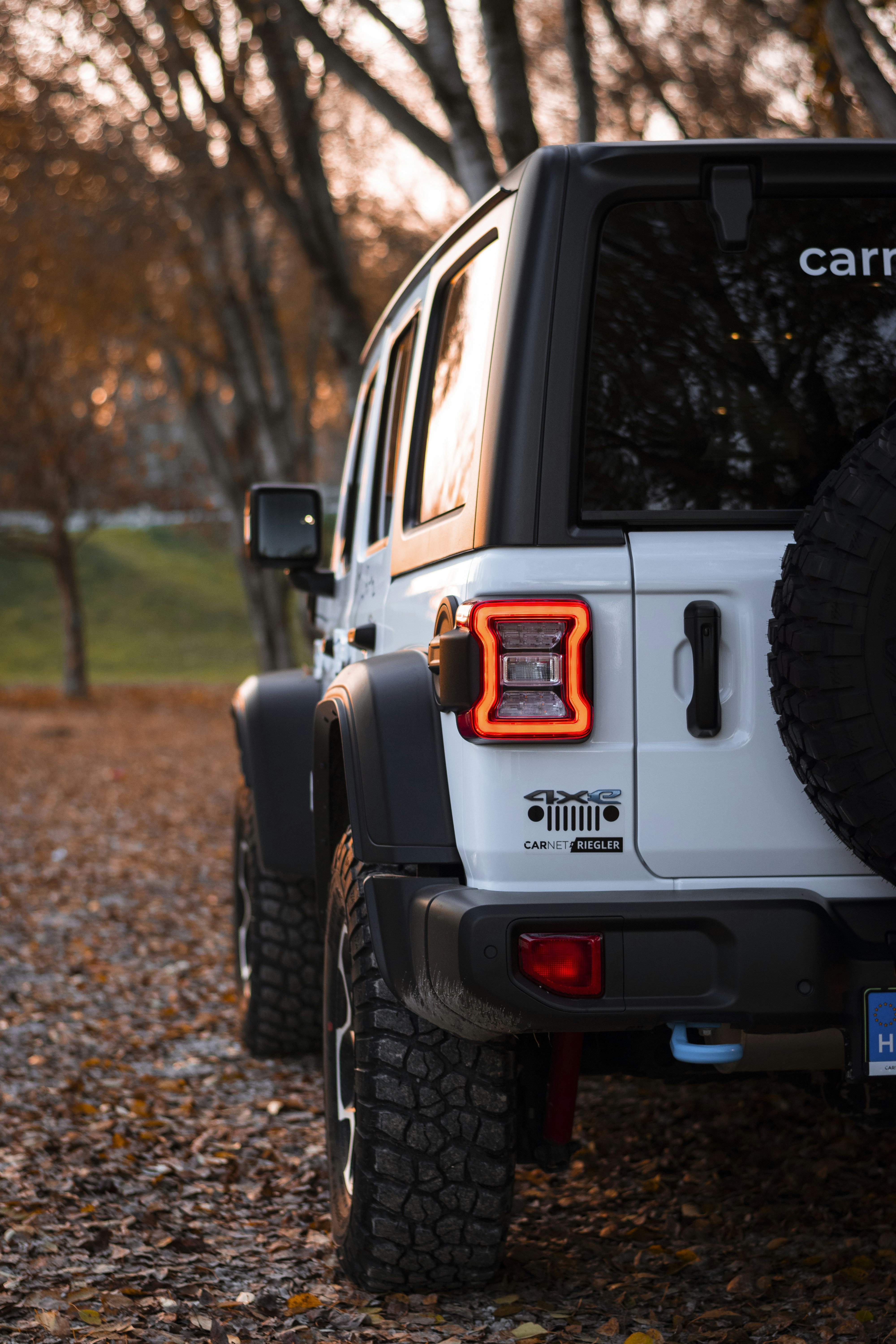 a white jeep parked on a dirt road