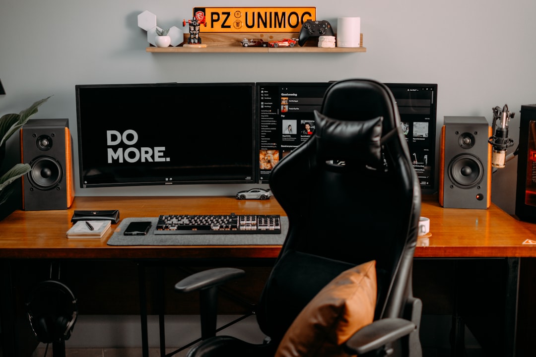 a person sitting at a desk with a computer and speakers,