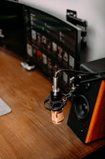 A warm, earthy-toned workspace with a microphone, headphones, and historical books arranged neatly.