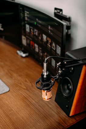 A warm, earthy-toned workspace with a microphone, headphones, and historical books arranged neatly.