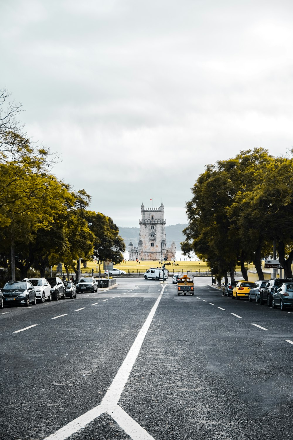 a road with cars and trees on the side