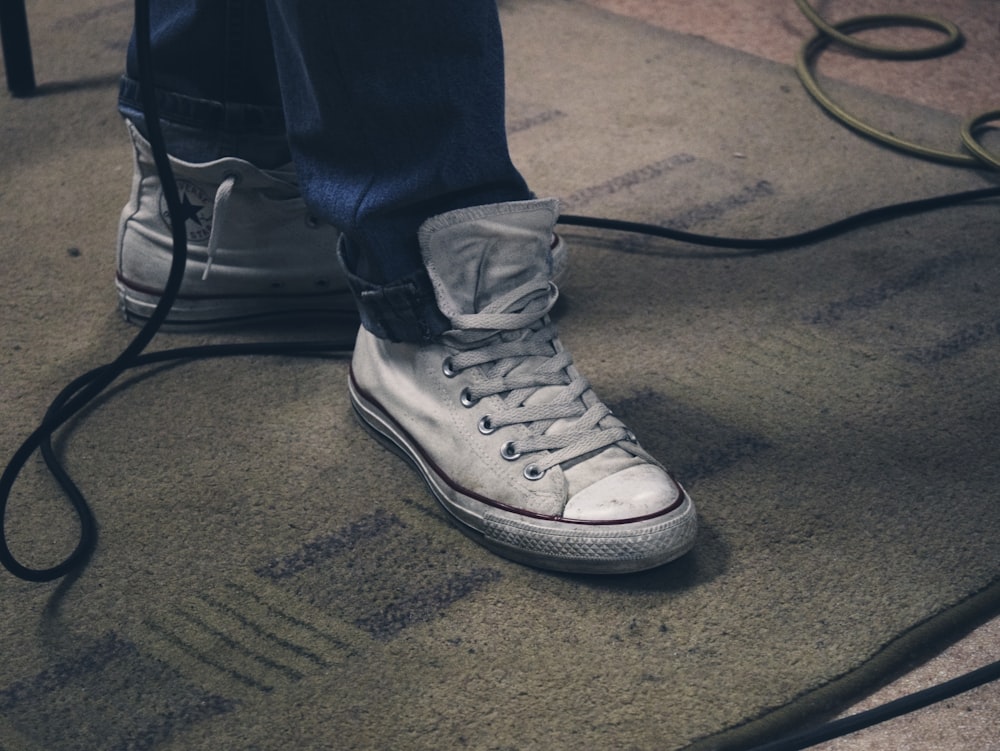 a person's feet with white sneakers