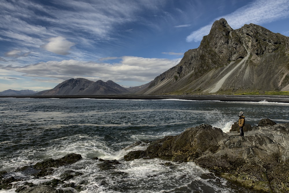 a person standing on a rocky shore