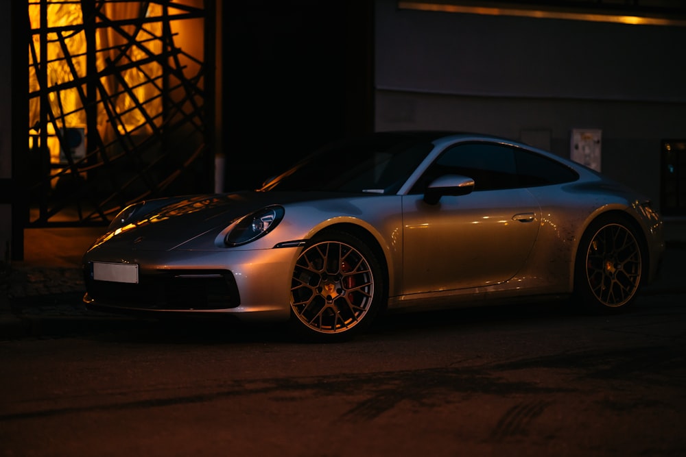 a silver sports car parked in a dark room