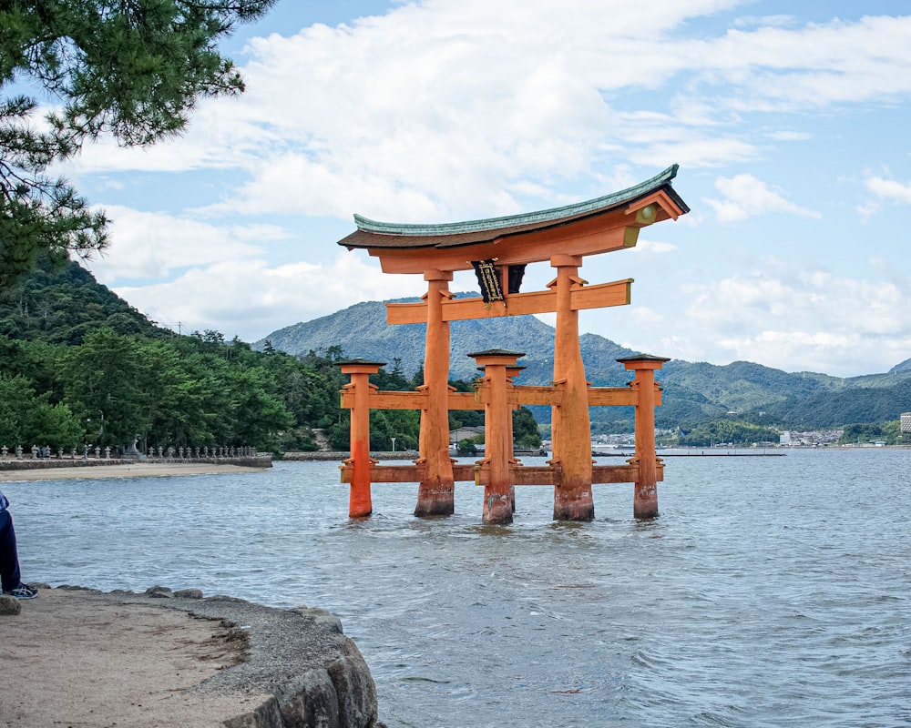 eine Struktur im Wasser mit Itsukushima im Hintergrund