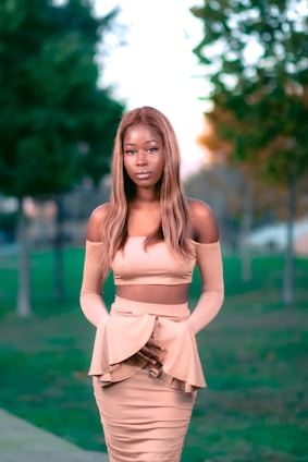 A stylish woman wearing a casual-elegant outfit in a serene outdoor setting.
