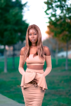 A sunlit outdoor shot featuring a flowing beige blouse paired with tailored trousers.