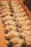 Rows of crescent-shaped cookies are arranged neatly, with a delicate dusting of powdered sugar on top. The cookies have their ends dipped in dark chocolate, creating a visually appealing contrast.