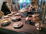 Showcase of various silver home utensils arranged neatly in a modern Riyadh showroom