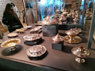 A collection of silver bowls with ornate edges displayed on a velvet cloth.