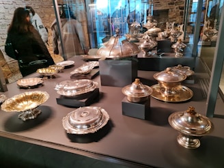 A collection of silver bowls with ornate edges displayed on a velvet cloth.