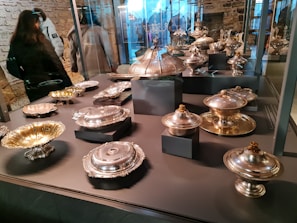 Showcase of various silver home utensils arranged neatly in a modern Riyadh showroom