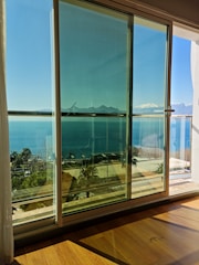 A technician repairing a sliding door at a sunny beachfront home.