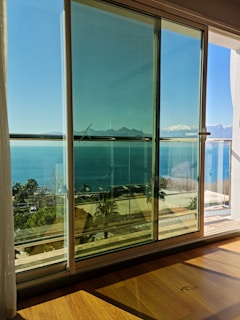Sunlight streaming through floor-to-ceiling windows of a Rosewood residence overlooking a serene ocean view.