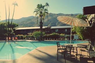 a pool with chairs and umbrellas by it