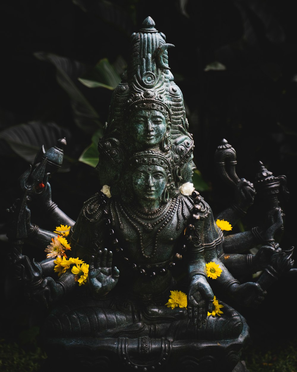 a statue of a person with a crown and flowers