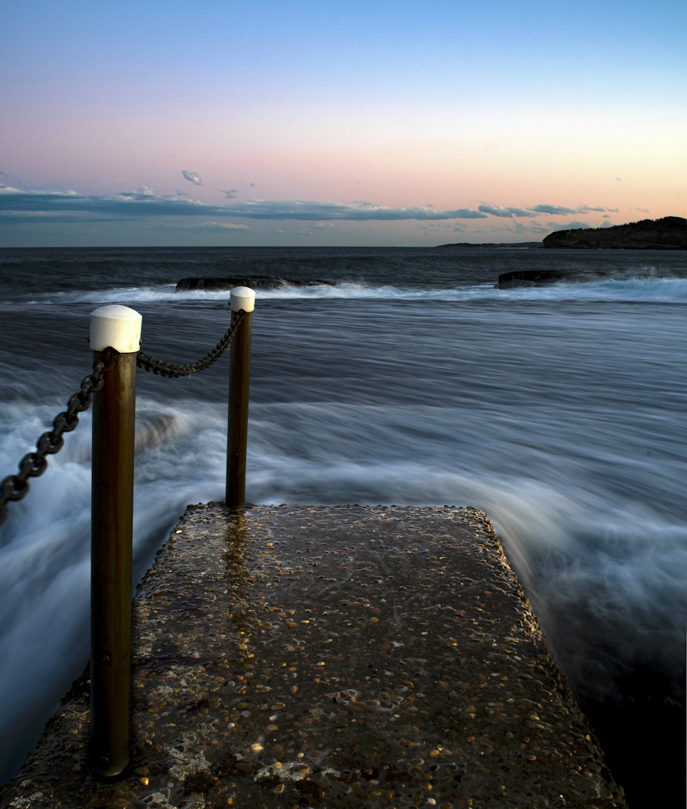 a rocky beach with a body of water in the background