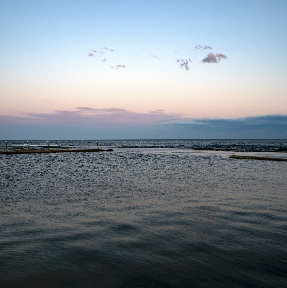 a body of water with a dock and a pier in the distance