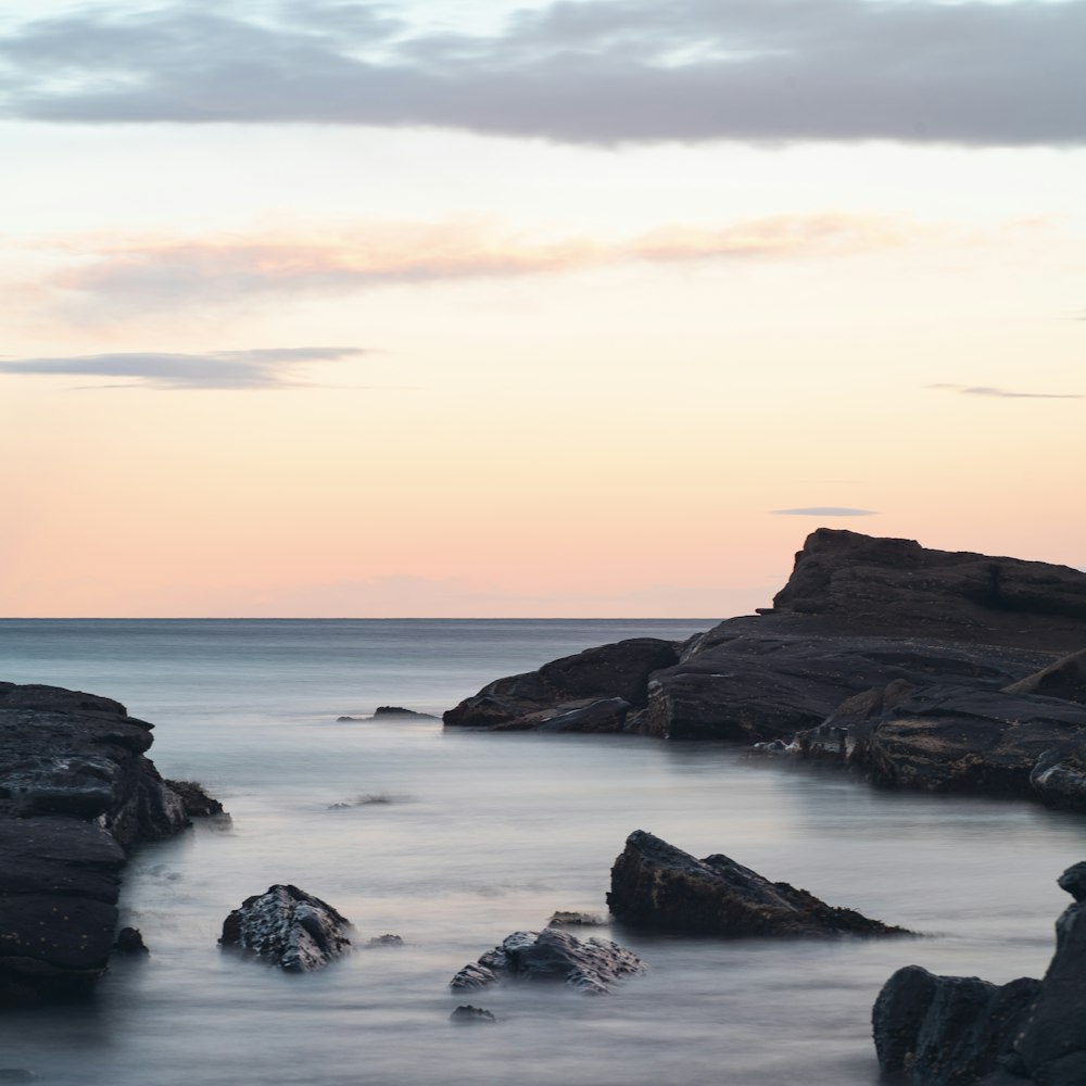 a rocky beach with a sunset