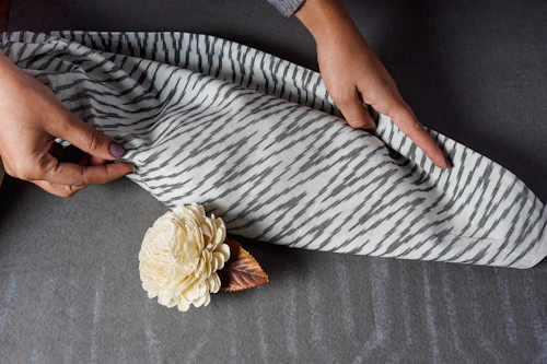Close-up of artisan hands holding handwoven cotton fabric