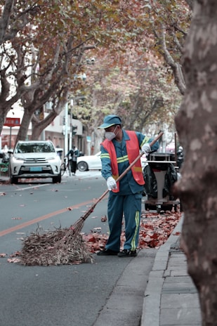A team member operating a leaf blower on a crisp autumn day.
