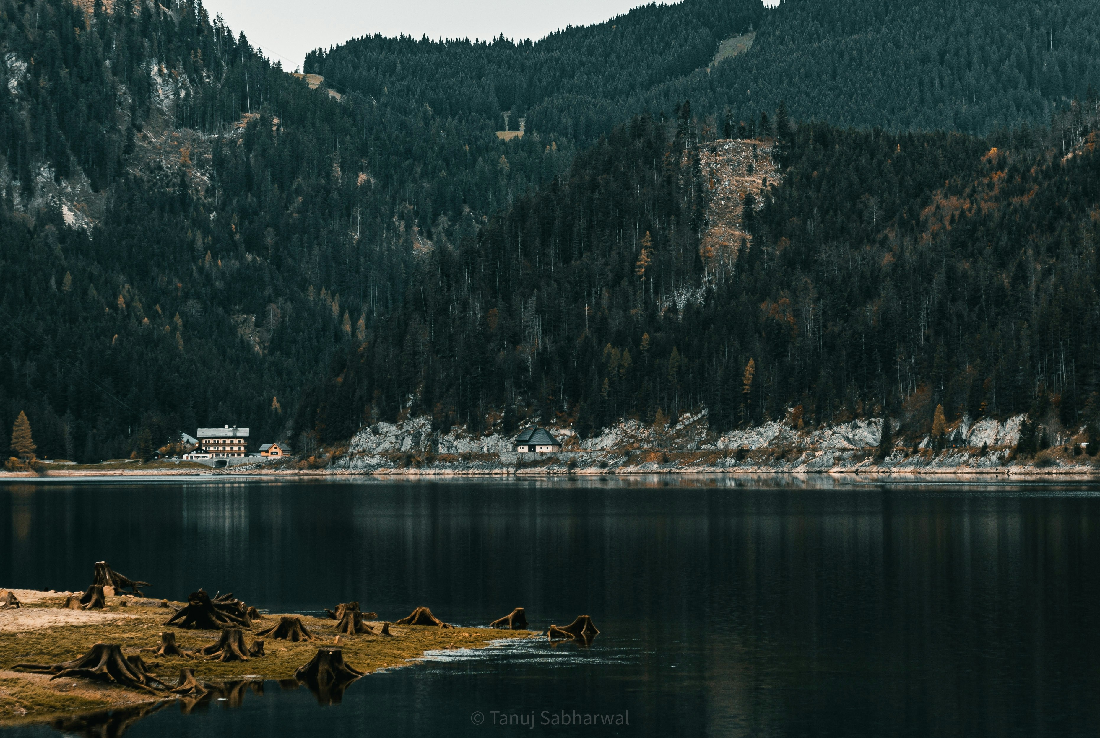 a body of water with a rocky shoreline and a building on the shore