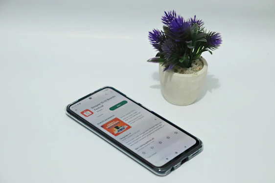 A friendly gardener showing a blooming urban garden with a tablet displaying the booking app interface.