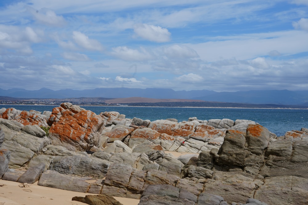 a rocky beach with water in the background