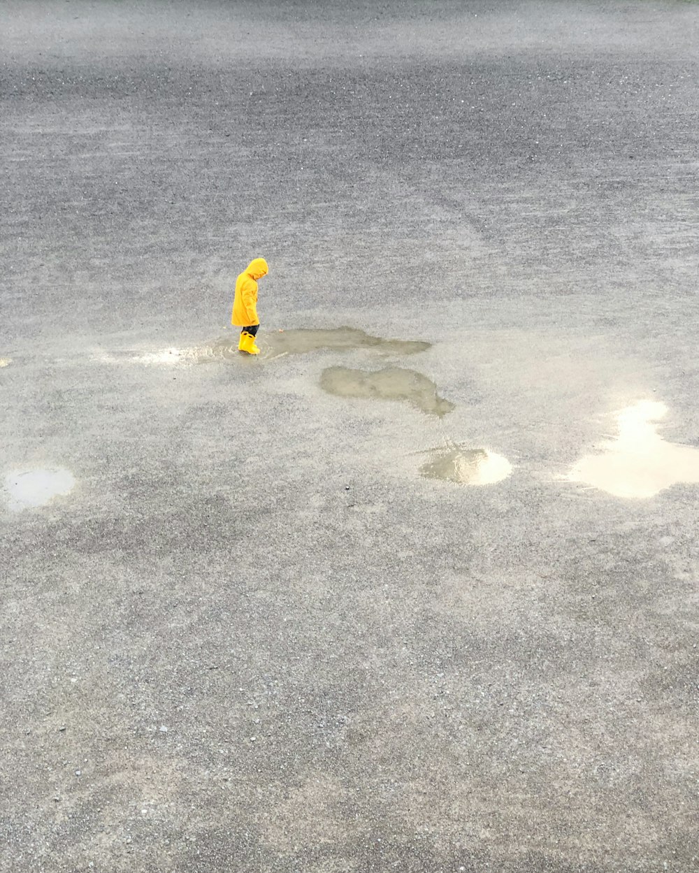 a person in a yellow jacket standing in the water