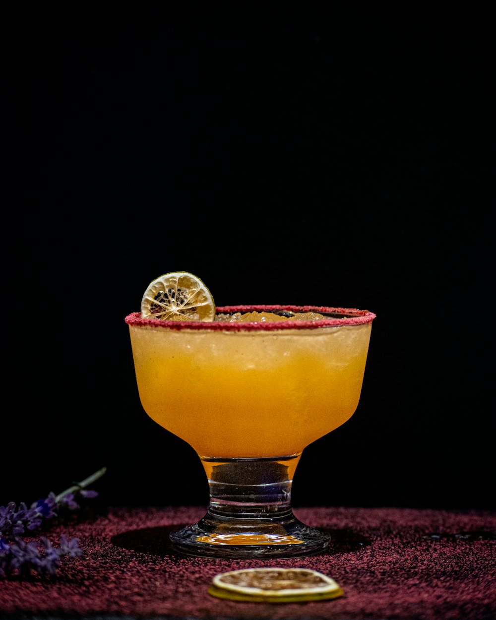 a glass of orange drink with a coin on top