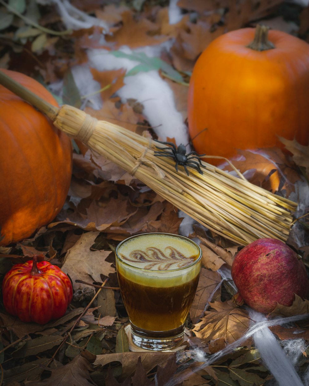 a group of pumpkins and a glass of beer on the ground