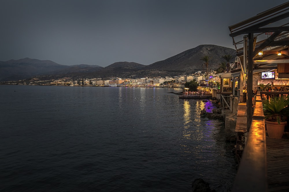 a body of water with buildings along it and mountains in the background