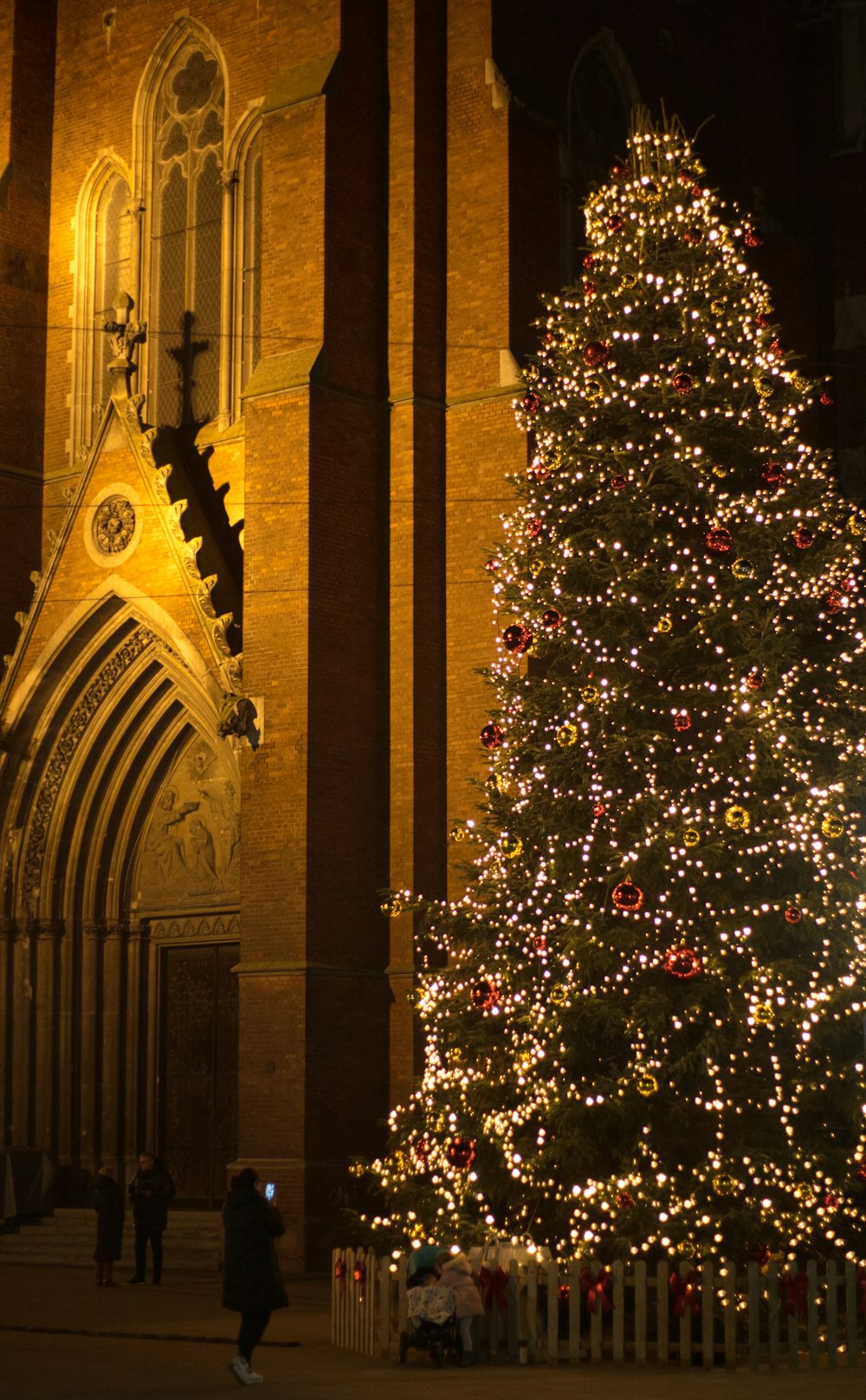 a large christmas tree in front of a church