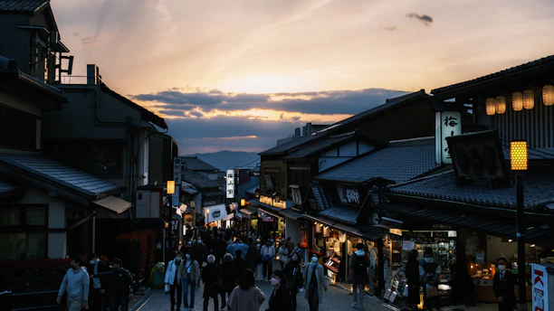 A vibrant street scene in Tokyo at dusk, with colorful lanterns glowing and people strolling.