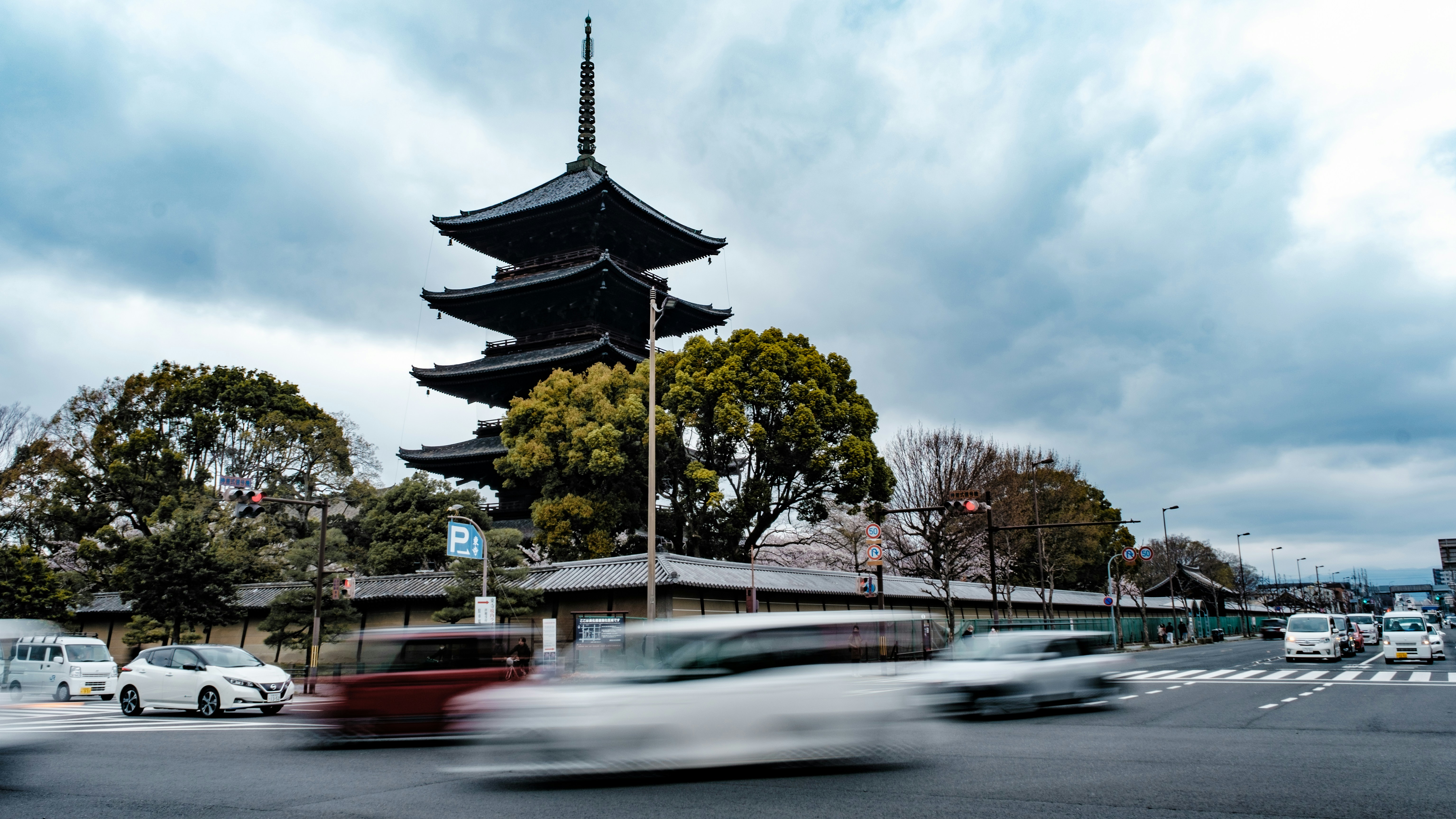 A street with cars and a tower in the background