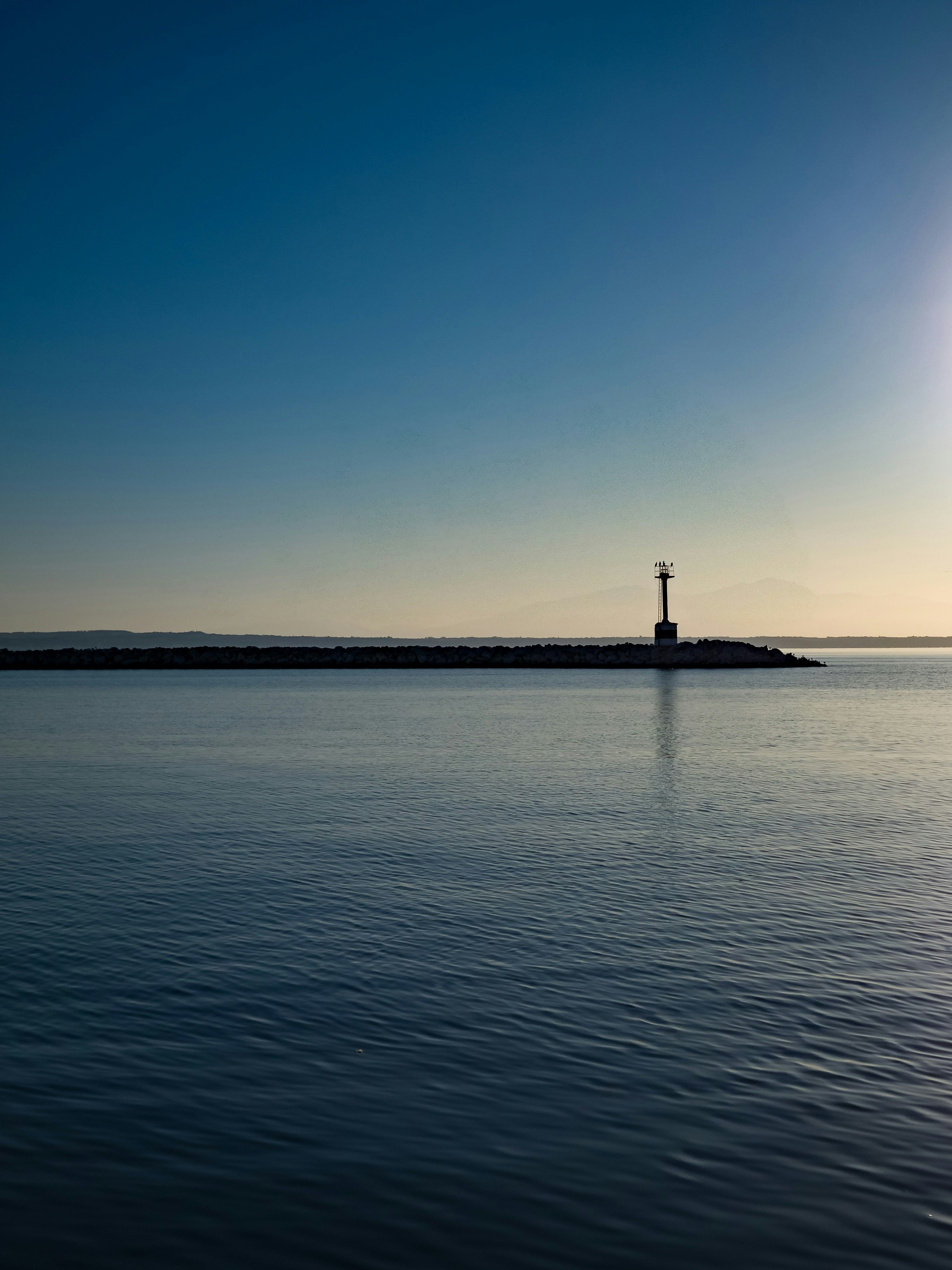 a body of water with a lighthouse in the distance