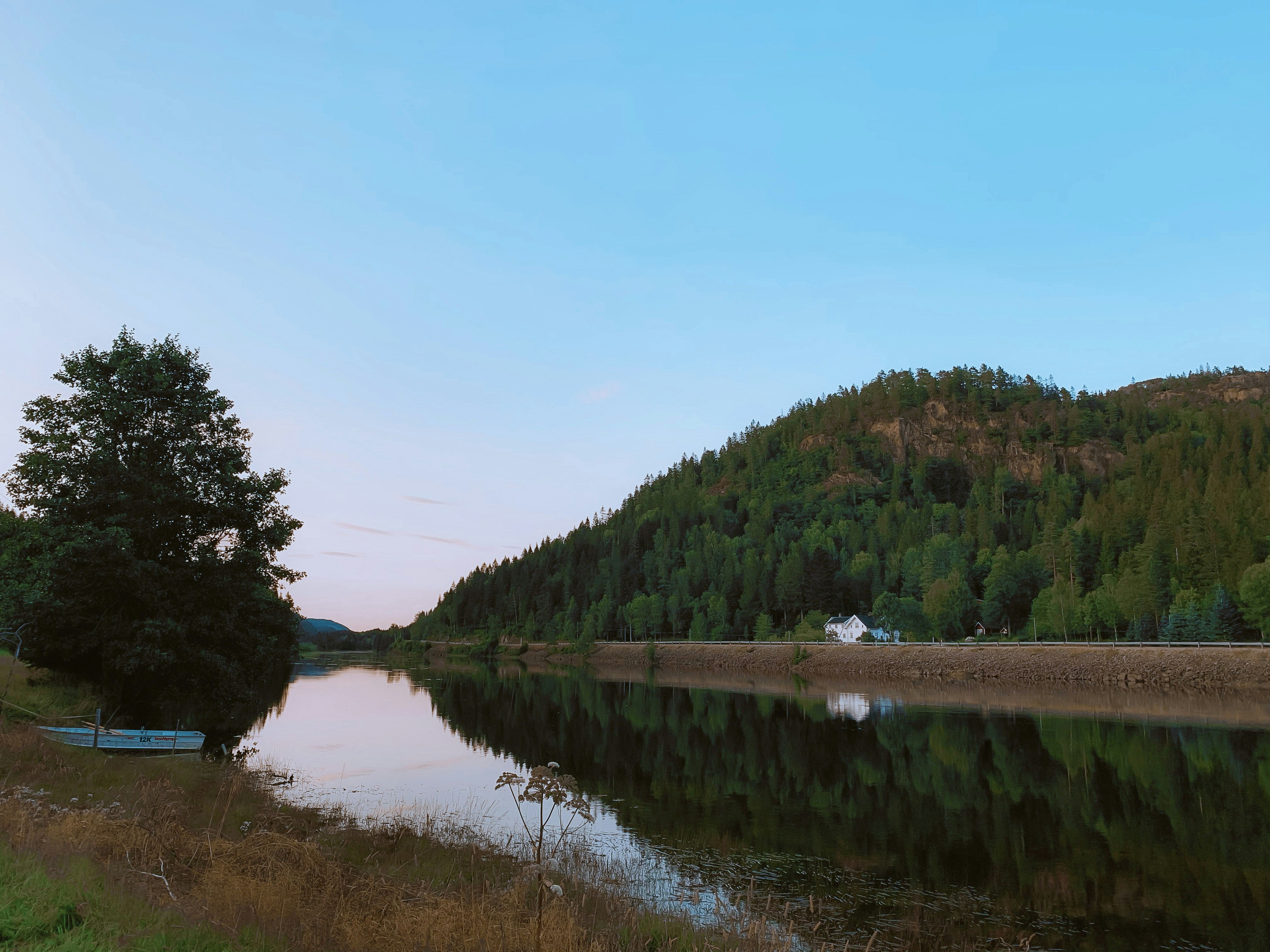 a body of water with trees and hills in the background