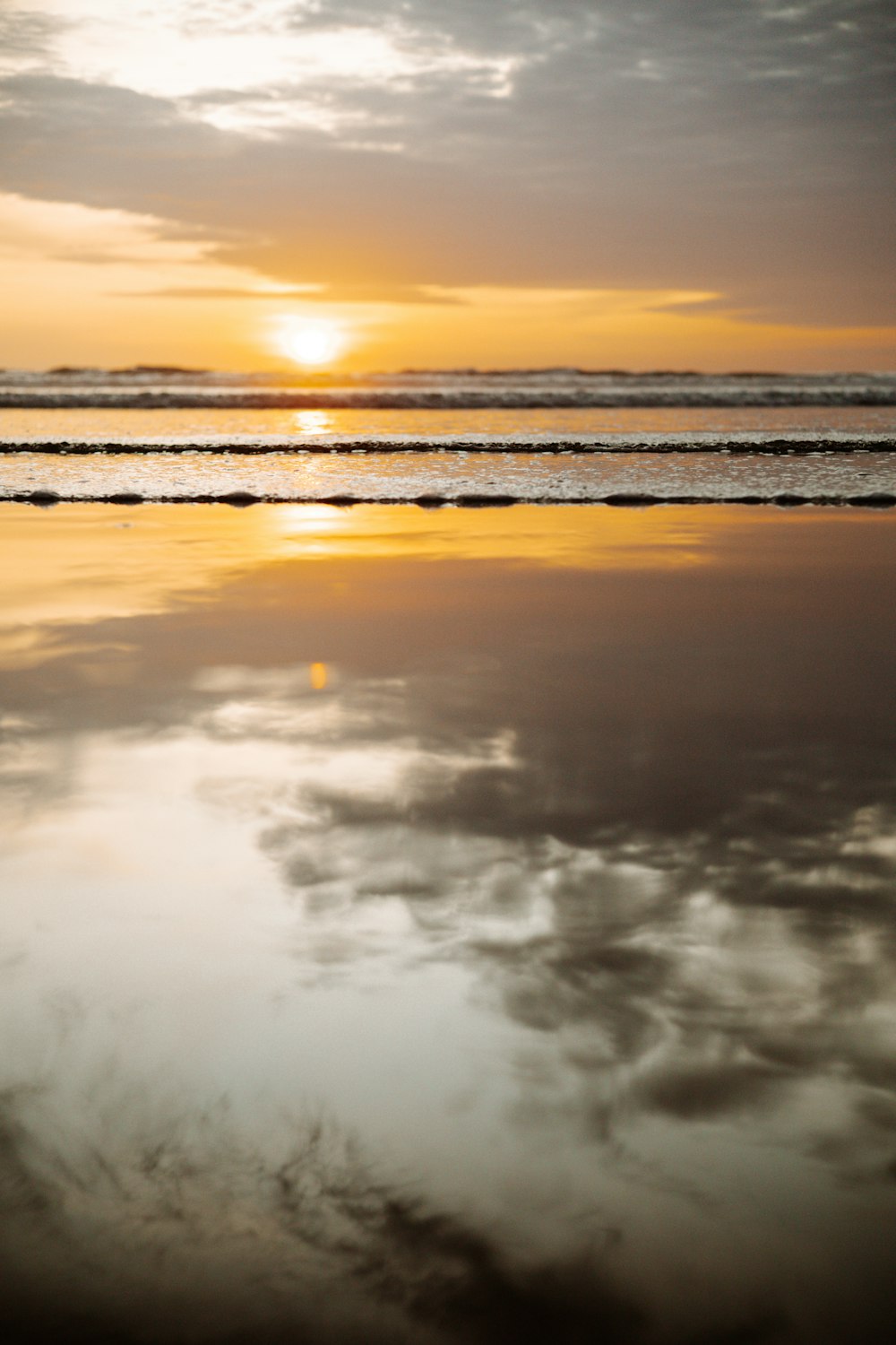 a beach with clouds and the sun