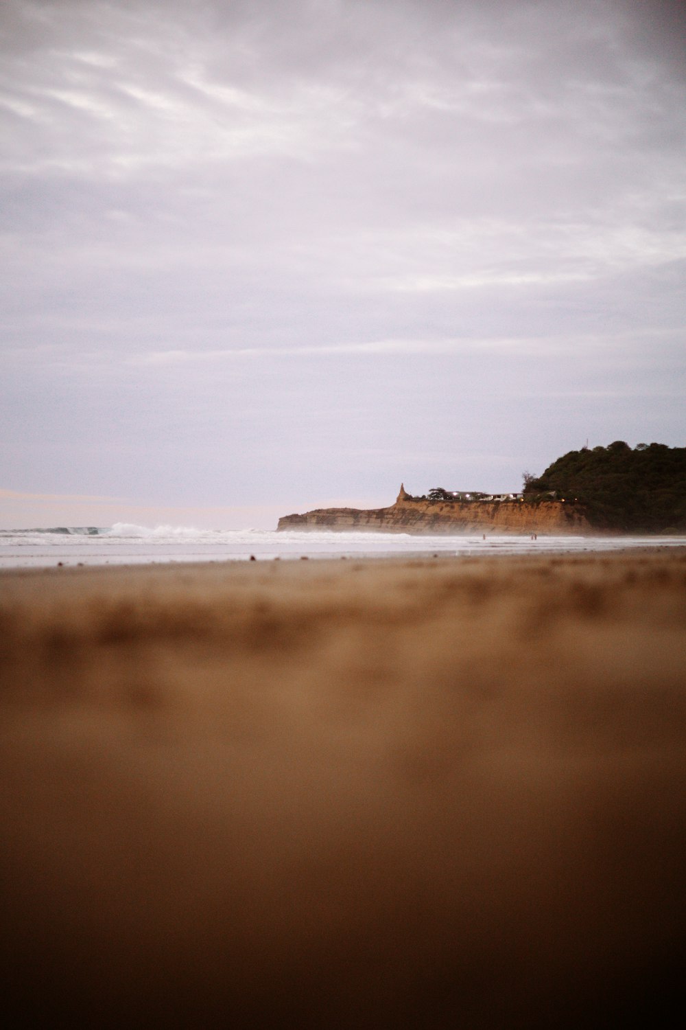 a beach with a hill in the distance