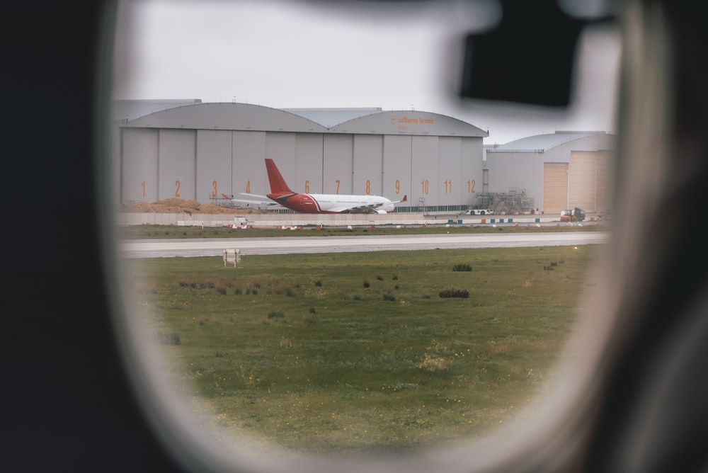 a window with a view of an airplane on the runway