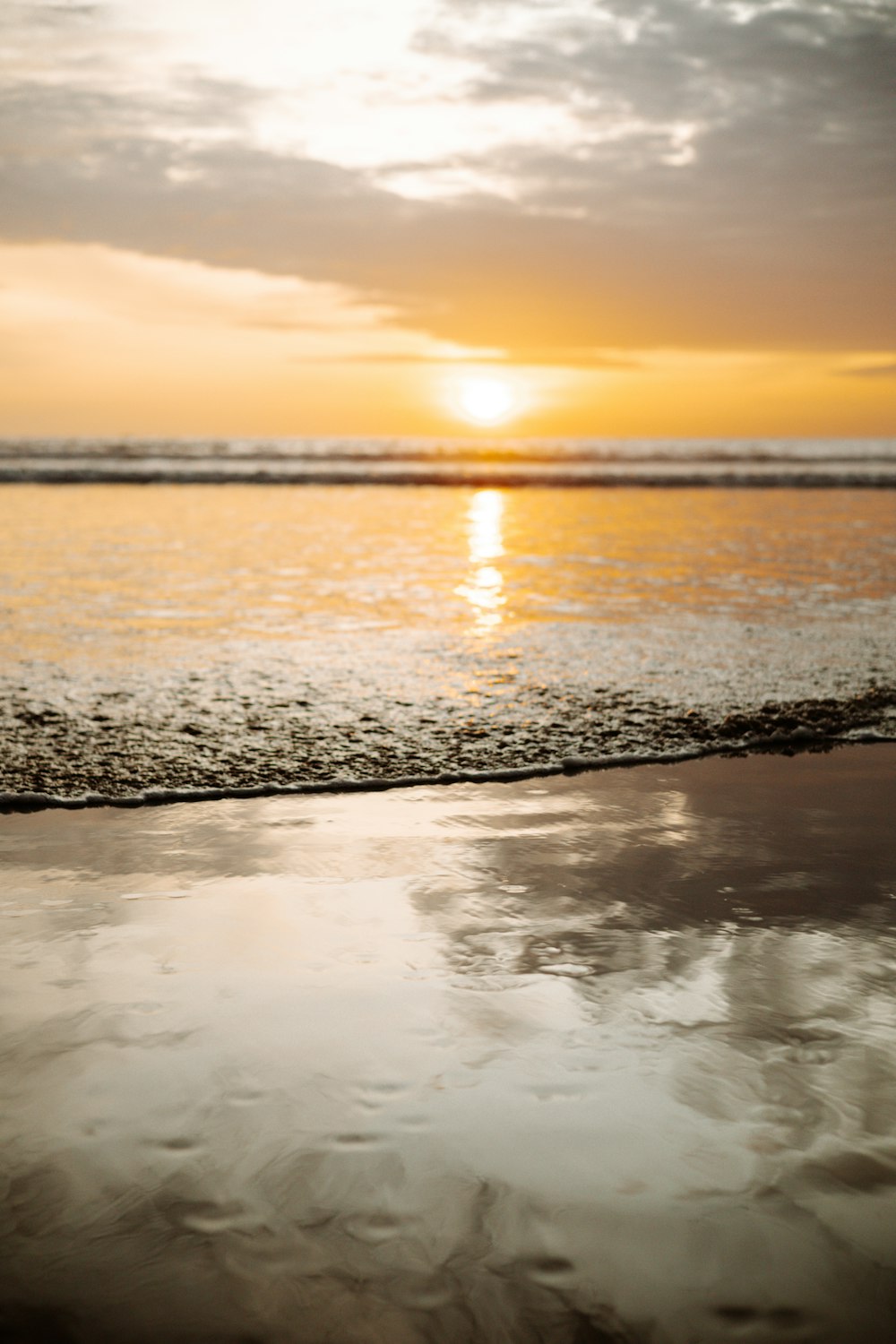 a beach with the sun setting