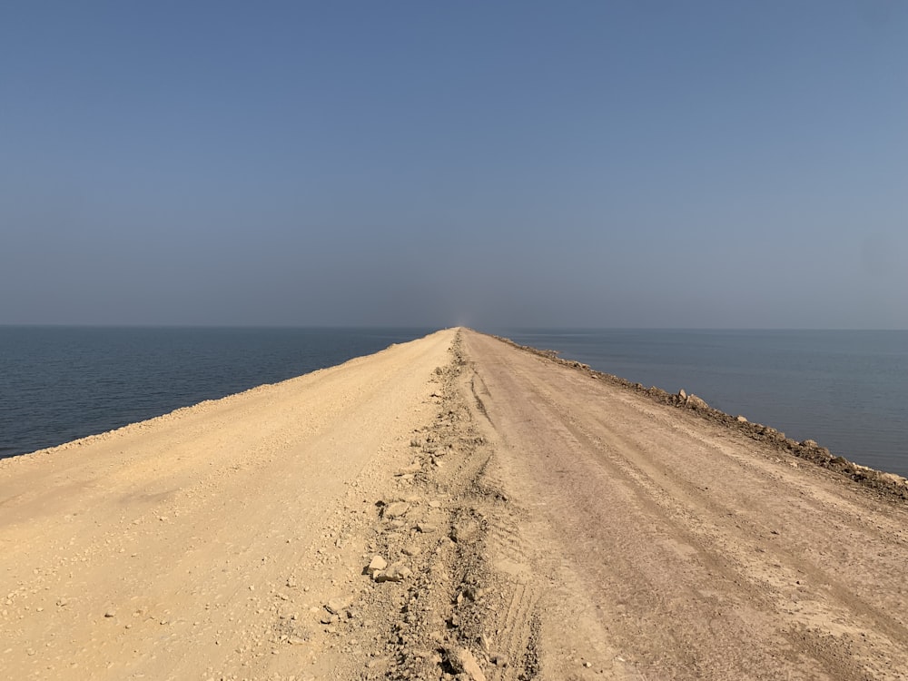 a sandy beach with water in the background