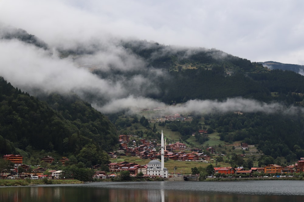 a city with a body of water and mountains in the background